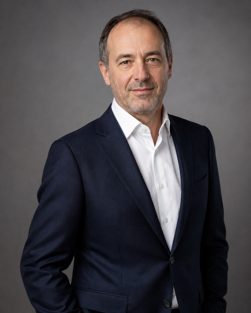 Portrait professionnel masculin en veste sur fond gris, pour dirigeant, consultant ou communication corporate.