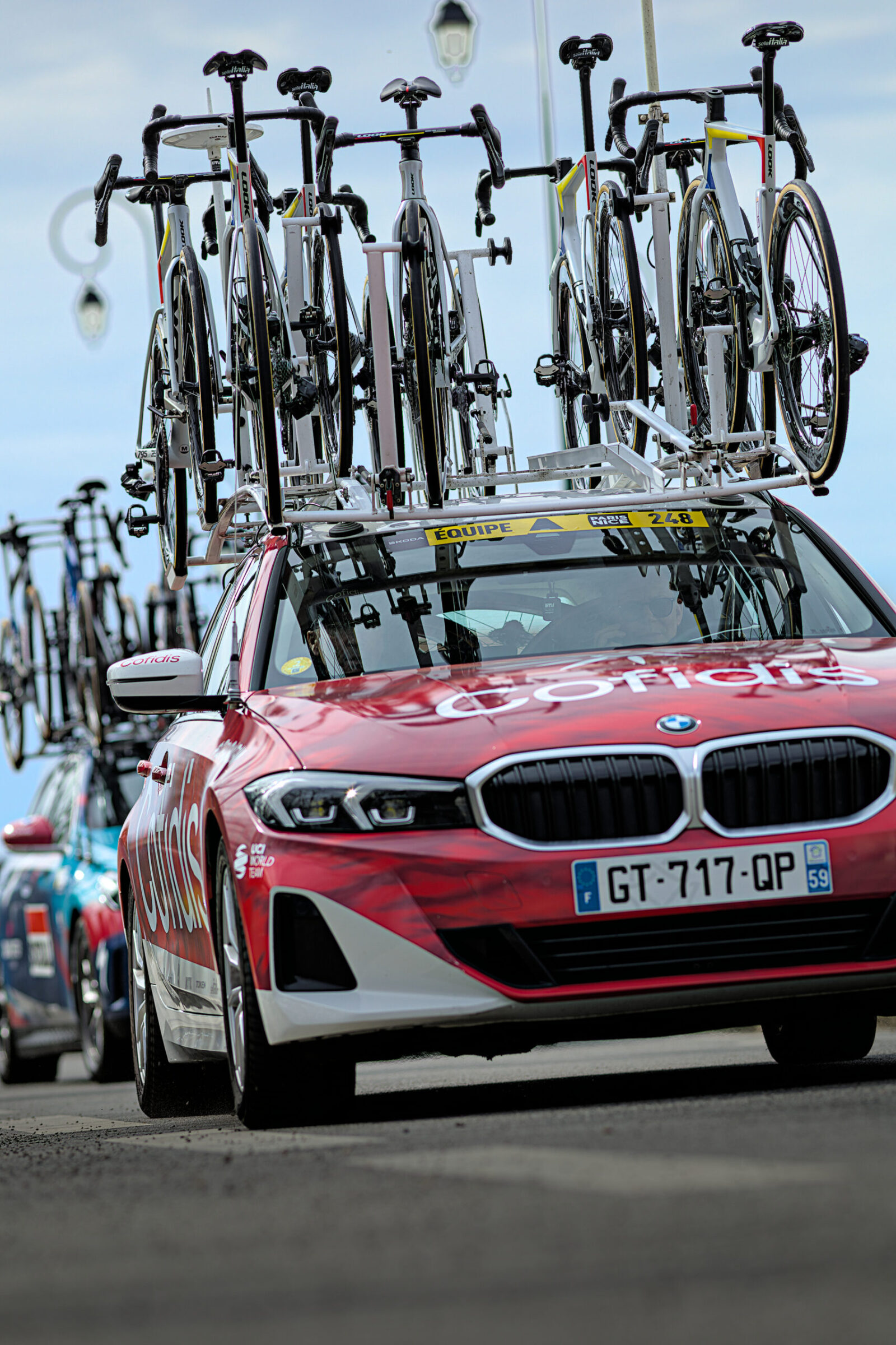 Voiture d’équipe et vélos photographiés lors d’un événement cycliste professionnel.