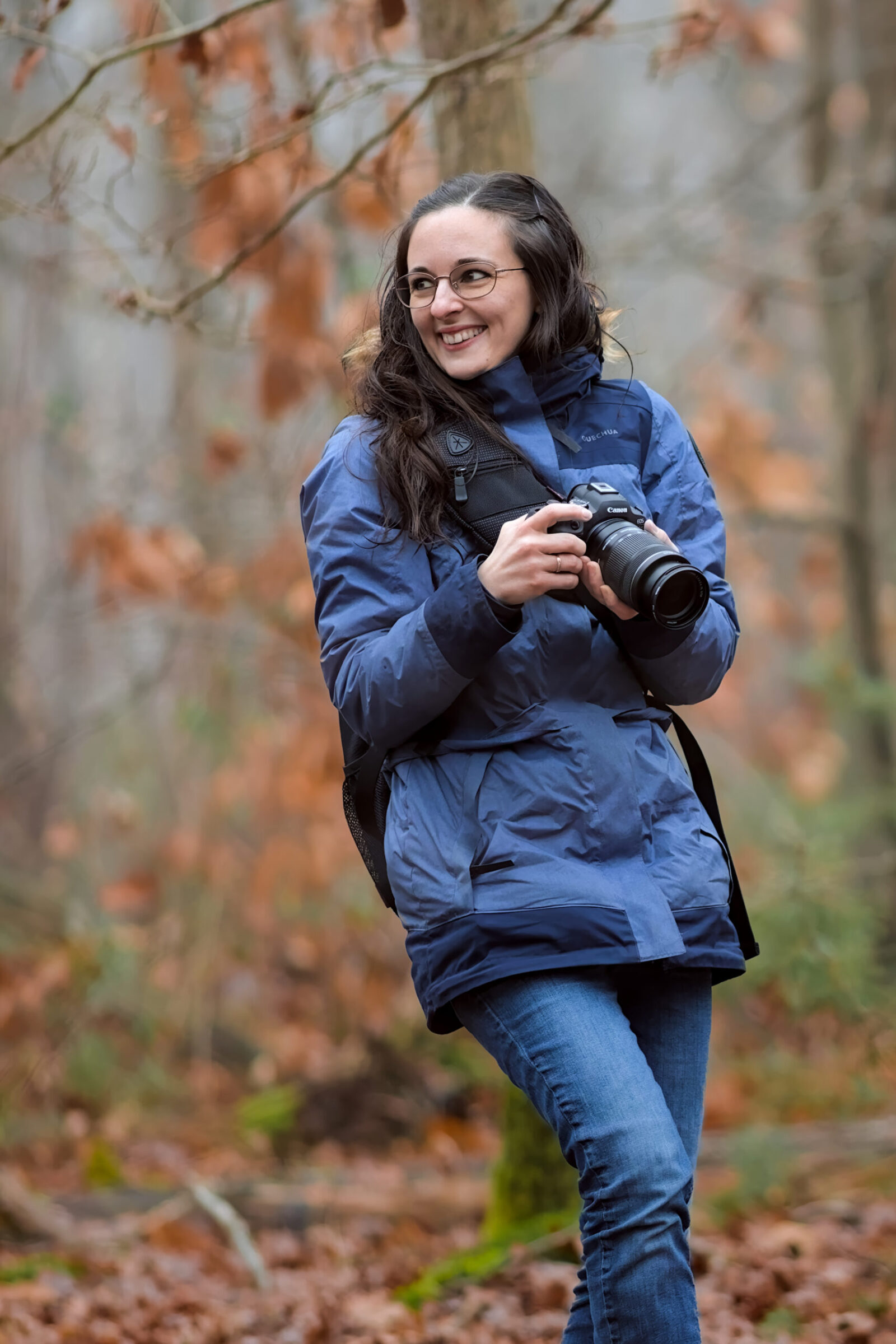Portrait en situation d’une photographe professionnelle lors d’une séance canine en extérieur.